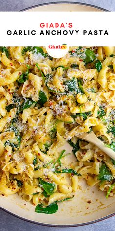 a pan filled with pasta covered in cheese and spinach