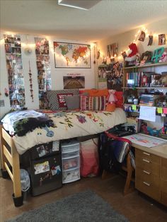 a dorm room with a bed, desk and bookshelf full of stuff on the wall