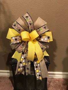 a large yellow and gray bow on top of a black box with polka dot dots