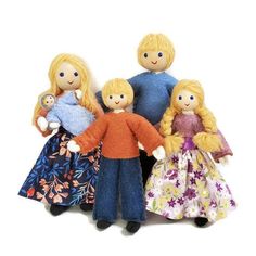 three dolls are standing next to each other in front of a white background and one is holding a doll