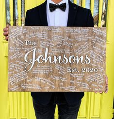 a man in a tuxedo holding up a sign that says the johnsons