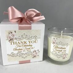 a white candle with a pink ribbon around it and a thank you card next to it