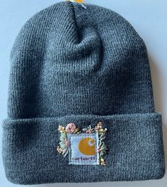 a gray beanie with a patch on it