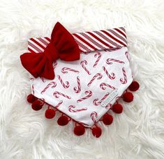 a red and white dog bandana with candy canes on it's side