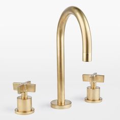 a gold faucet with two handles and three soap dispensers in front of a white background