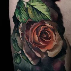 a close up of a tattoo with a rose on it