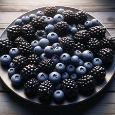 blueberries and raspberries on a plate with blackberries in the middle, sitting on a wooden table