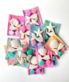 several seashells and starfish are on top of candy wrappers in different colors