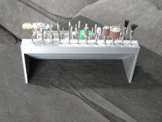 a white table topped with lots of different types of toothbrushes on top of each other