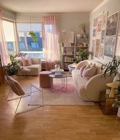 a living room filled with furniture and lots of windows covered in pink draping