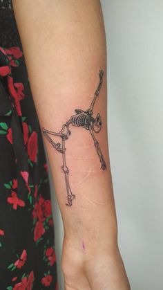 a woman's arm with a skeleton tattoo on it