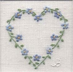 a cross stitch heart with blue flowers on it