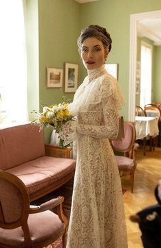 a woman in a white dress holding a bouquet of flowers