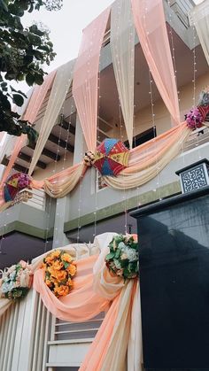 an outside view of a building decorated with flowers and drapes hanging from the ceiling