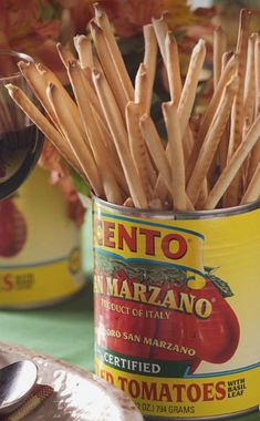 a can filled with toothpicks sitting on top of a table next to other tins