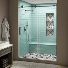 a bathroom with a walk in shower next to a white sink and a blue tiled wall