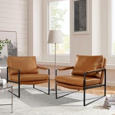 two brown leather chairs sitting next to each other in front of a white wall and floor