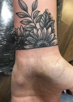 a black and white flower tattoo on the wrist