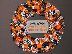 an orange and black wreath with words on it that says live to ride, ride to live