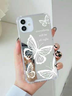 a woman holding a clear phone case with white butterflies on it and the words everything will be alright