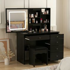 a bedroom with a desk, mirror and shelves filled with makeup products on it's sides