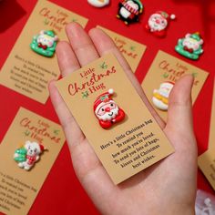 a hand holding a tiny christmas brooch with santa clause on it's lap