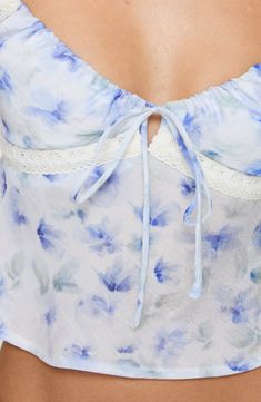 Sweeten the occasion in this lace-trimmed cropped cami designed with blue-hued blooms and a dainty neck tie. Hidden side-zip closure V-neck Spaghetti straps Lined bust 75% rayon, 25% polyester Hand wash, line dry Imported Spring Lace Camisole With Floral Print, Blue Lace Camisole For Spring, Summer Cropped Camisole With Lace Trim, Spring Lace Trim Cropped Camisole, Cropped Summer Camisole With Lace Trim, Summer Cropped Lace Camisole, Blue Cropped Camisole For Spring, Blue Camisole With Delicate Straps For Spring, Blue Floral Print Camisole For Spring