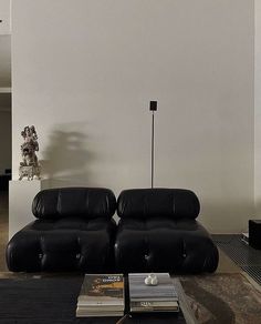 a living room with two black leather couches