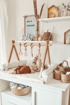 a baby laying on top of a white crib next to a shelf filled with items