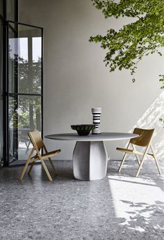 a table with two chairs and a bowl on it