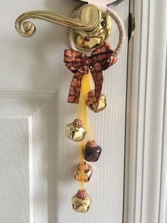 a door handle with bells hanging from it's side and a bow on top