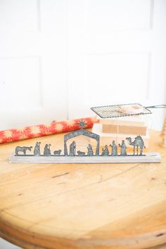 a wooden table topped with metal figurines and a candle holder on top of it