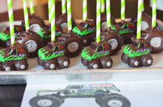 there are many chocolate cake pops with green candles in the shape of animals on them