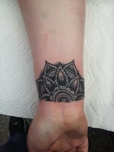 a woman's wrist with a tattoo on it that has a black and white design