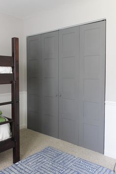 a bunk bed sitting next to a gray closet