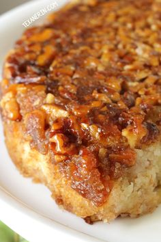 a close up of a piece of cake on a plate with pecans in it