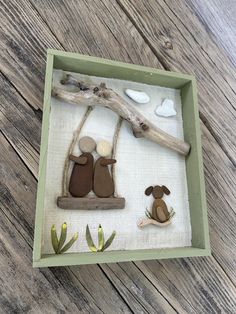 a wooden frame with some rocks in it and two dogs on the tree branch next to them