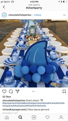 the table is set up with blue and white plates, water bottles, and balloons