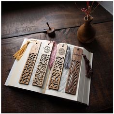 an open book with tassels on top of it sitting on a wooden table