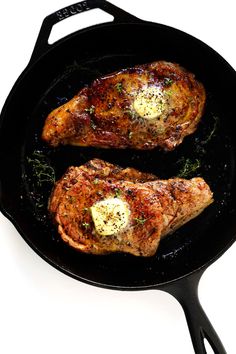 two steaks are cooking in a skillet