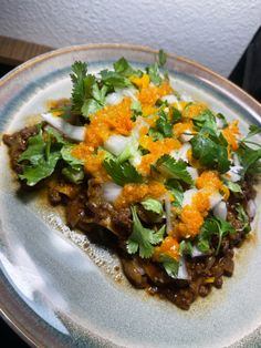 a white plate topped with lots of food on top of a wooden table next to a wall