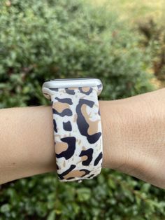 an animal print apple watch band on someone's arm