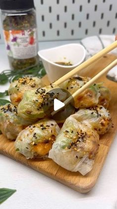 some food is sitting on a cutting board with chopsticks