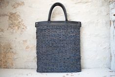 a blue and black bag sitting on top of a white table next to a wall