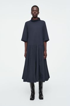 Slightly dropped at the waist, this funnel-neck midi dress has a flared A-line silhouette with pintucked pleats that lend volume. It comes in an enduring navy tone that's easy to style and is made from panels of contrasting fabrics. Relaxed fitRecycled nylon reduces our demand on limited natural resources and reduces greenhouse gas emissions  Woven Shell: 70% Recycled polyamide (Recycled nylon), 30% Cotton. Knitted Shell: 100% Cotton. Excluding trims / Machine wash Back length of size S is 123.5cm / Model wears size S Belted Cape, Women Magazines, Navy Midi Dress, Natural Resources, Blue Midi Dress, Navy Dress, Funnel Neck, Drop Waist, Funnel