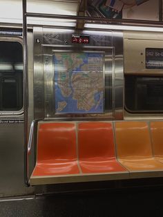 a subway car with orange seats and a map on the wall