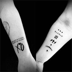 two people with tattoos on their arms holding each other's hands and one has the number seventy