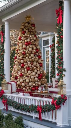 a decorated christmas tree on the front porch with red and gold ornaments hanging from it