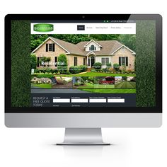 a computer screen showing the homepage for a real estate listing company, with green grass in front of it