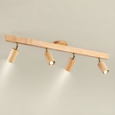 three light wooden track lighting fixture with dimmers on the sides and two spotlights in the middle